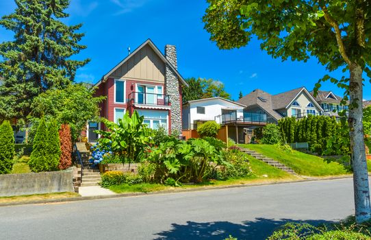 Beautiful suburban house with landscaped terrace and blue sky background. Residential house at sunny day in British Columbia