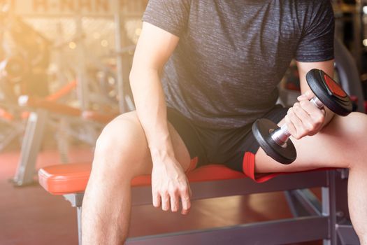 Bodybuilder working out with dumbbell weights at the fitness gym. Female bodybuilder doing exercises with dumbbell. Fitness muscular body. Diet lifestyle, weight loss, healthy concept.