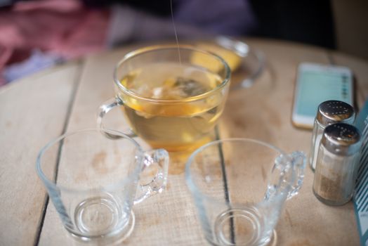 Honey being poured into cup with hot water