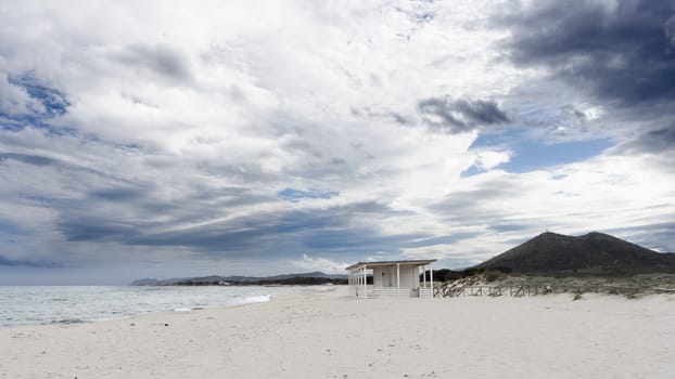 Empty beach without tourists with closed chiringuito and impressive cloudy sky