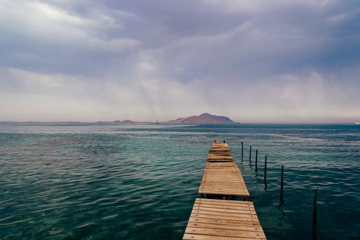 Old wooden pier on the Red sea at overcast day