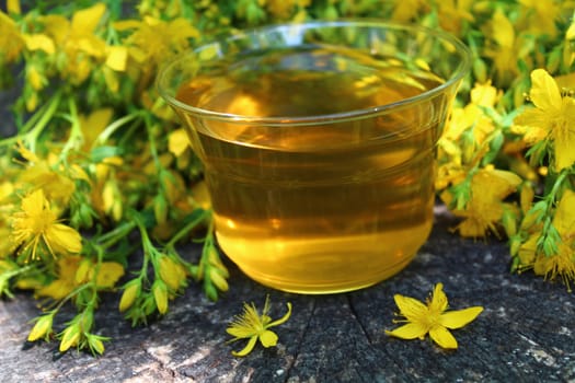 The picture shows herb tea on an old weathered tree trunk