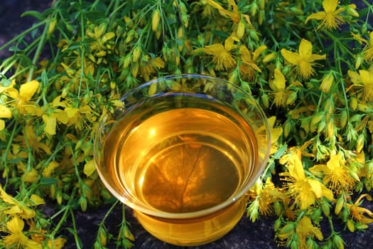 The picture shows herb tea on an old weathered tree trunk