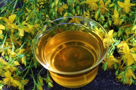 The picture shows herb tea on an old weathered tree trunk