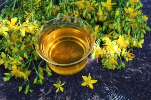 The picture shows herb tea on an old weathered tree trunk