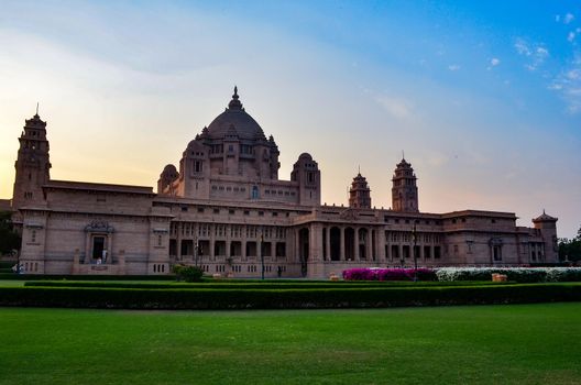 Majestic view of the Umaid Bhawan palace and hotel against a setting sun in Jodhpur, Rajasthan, India. This elegant hotel in a grand building was once home to the Jodphur royal family.