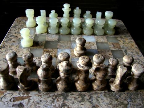 Closeup of a wooden Chessboard. Chess is a two-player strategy board game played on a checkered board with 64 squares arranged in an 8×8 grid, believed to be derived from the Indian game Chaturanga.