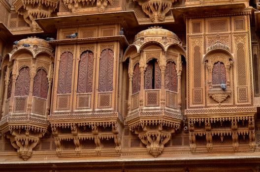 Traditional Rajasthani haveli with a decorated window at Patwon ki haveli in Jaisalmer, Rajasthan, India. Series of early-1800s palaces, now a museum featuring intricate carvings, furniture & artwork.