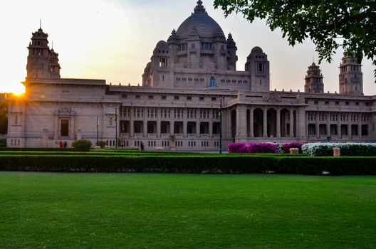 View of the Umaid Bhawan palace and hotel against a setting sun in Jodhpur, Rajasthan, India. This elegant hotel in a grand building was once home to the Jodphur royal family