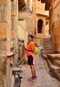 Young woman posing in the by-lanes of Jaisalmer, Rajasthan. Jaisalmer is also known as the golden city because of the Jaisalmer Fort which is golden in colour.