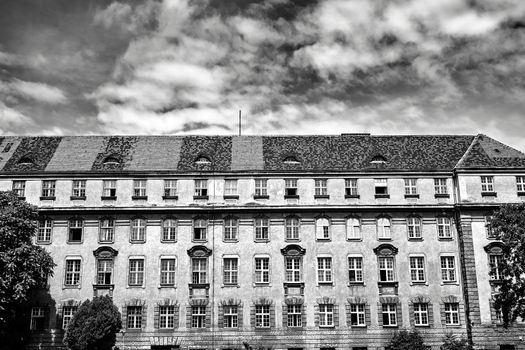 Facade with windows of historic tenement house in the city of Poznan, black and white