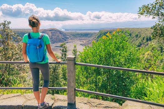 Hawaii hiking travel tourist hiker girl looking at view of Kilauea Iki crater lava field lake in Big Island, Hawaii. United states of America summer vacation popular attraction.