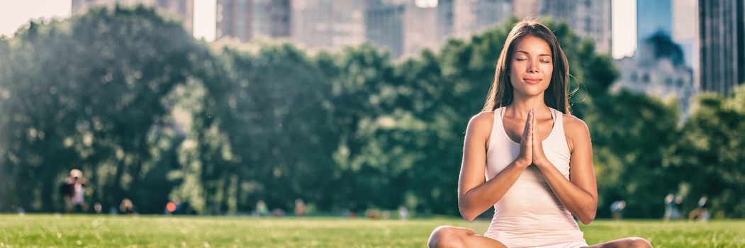 Yoga woman meditation praying outside in city park wellness banner panorama .Summer exercise lifestyle active young Asian girl meditating background.