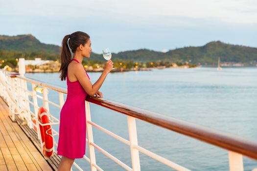 Luxury cruise ship honeymoon vacation woman drinking wine during dinner at outdoor restaurant deck of sailing boat in Tahiti, French Polynesia. Elegant lady drinking wine on balcony watching sunset.