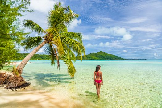 Vacation Luxury Travel woman walking on Tahiti paradise motu beach Bora Bora on holidays on Bora Bora with. Happy girl Bikini in Tahiti, French Polynesia.