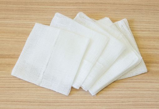 white gauze pads on wooden background