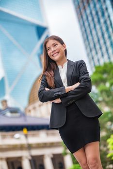 Business woman confident portrait in Hong Kong. Businesswoman standing proud and successful in suit cross-armed. Young multiracial Chinese Asian / Caucasian female professional in central Hong Kong.