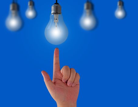 Idea concept, light bulb and hand on blue background