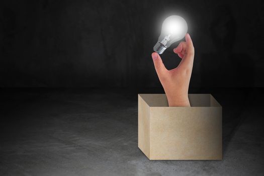 Think outside the box concept, hand holding light bulb, idea and inspiration 