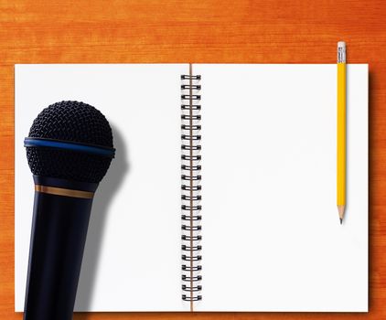 Journalist interview concept, open notebook and yellow pencil on wood background