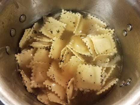 pot of boiling water with ravioli pasta cooking