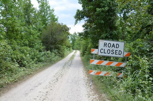 orange and white road closed sign with path or trail