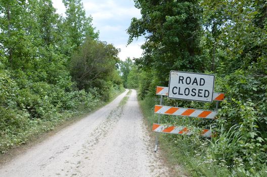 orange and white road closed sign with path or trail