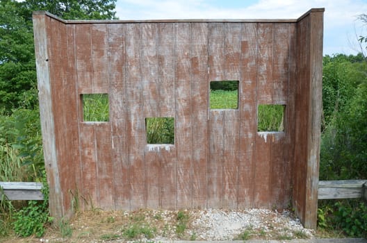 wood animal blind with square holes or viewing windows