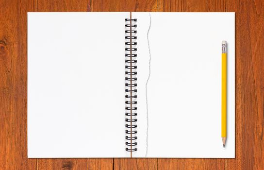 Notebook, torn paper and yellow pencil on brown wood background, business and education concept