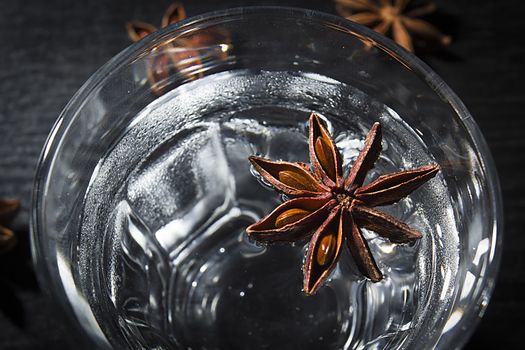 Anise vodka in a glass on a wooden surface