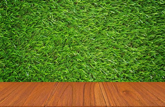 Wood table on green grass background, montage or display product, ecology and nature concept