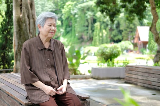 elder woman resting in garden. asian elderly female relaxing outdoors. senior leisure lifestyle
