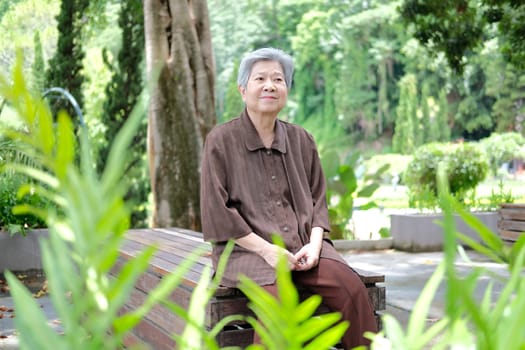 elder woman resting in garden. asian elderly female relaxing outdoors. senior leisure lifestyle