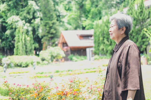 elder woman resting in garden. asian elderly female relaxing outdoors. senior leisure lifestyle