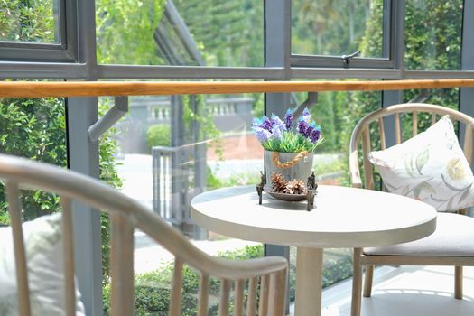 fake plant flower in metal tin bucket. chair in living room home interior