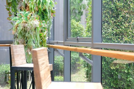 fake green leaves plant decorating near window in living room home interior