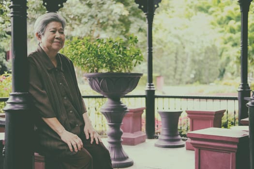 asian elder female woman resting relaxing on balcony terrace at home. elderly senior leisure lifestyle