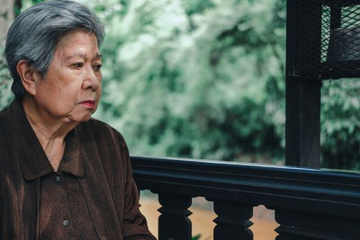 asian elder female woman resting relaxing on balcony terrace at home. elderly senior leisure lifestyle