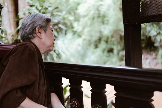 asian elder female woman resting relaxing on balcony terrace at home. elderly senior leisure lifestyle