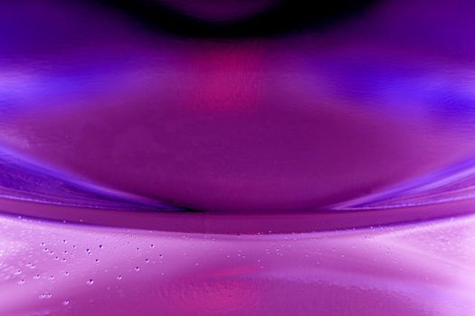 Macro shot of water with bubbles inside a plastic bottle with light and colors effects