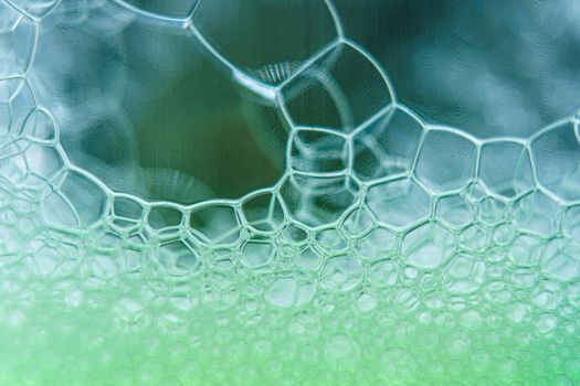 Abstract macro clean green foam shot background of soap bubbles