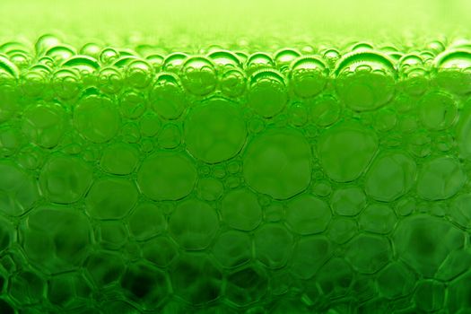 Abstract macro clean green foam shot background of soap bubbles with light and color reflections effects
