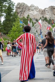 Back view of woman dressed in US colors at Mount Rushmore National Monument, Black Hills.