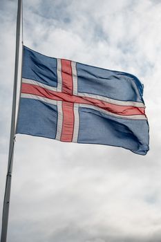 Iceland flag against a cloudy sky in Iceland.