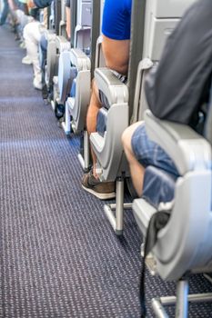 Back view of airplane aisle and seats during flight.