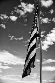 American flag against blue sky landscape, USA.
