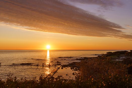 Orange sky with gorgeous cloud on an old sea pier in dawn or sunset