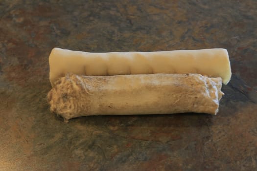 rawhide is considered a controversial dog chew due to the risk of dogs choking. Photo showing partly chewed rawhide.