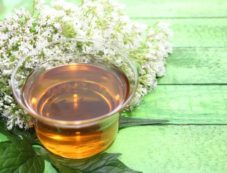 The picture shows valerian tea on green boards