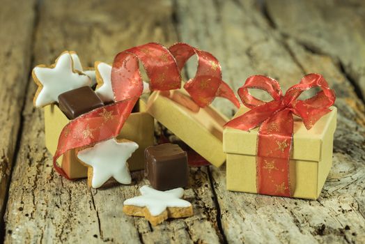 Christmas pastry and chocolate in gift box with red ribbon on wooden table